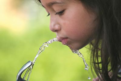 Close up of native girl drinking from water fountain